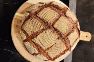 Krusten-Bauernbrot Doppelback – rustikaler Laib mit tief eingeschnittener Kruste auf Holzbrett von oben